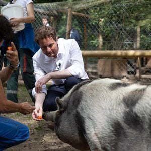 Le ministre délégué aux Transports Clément Beaune caresse un cochon lors d'une visite dans un refuge de la Fondation Brigitte Bardot à Bazoches-sur-Guyonne, dans l'ouest de Paris, le 7 août 2023. Photo par Raphael Lafargue/ABACAPRESS.COM