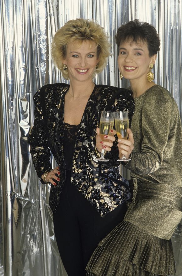 Archives - En France, à Paris, en studio, Fabienne EGAL, la brune, et Evelyne LECLERCQ, la blonde, posant en tenue de soirée, tenant chacune une coupe de champagne. 01/12/1986 
Michel MARIZY via Bestimage