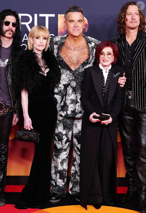 Robbie Williams (au centre) Kelly Osbourne (au centre à gauche) et Sharon Osbourne (au centre à droite) assistant aux Brit Awards 2026 au Co-op Live, Manchester le samedi 28 février 2026. Crédit photo : Ian West/PA Wire.
