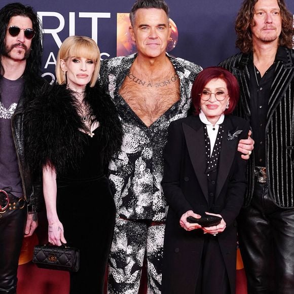 Robbie Williams (au centre) Kelly Osbourne (au centre à gauche) et Sharon Osbourne (au centre à droite) assistant aux Brit Awards 2026 au Co-op Live, Manchester le samedi 28 février 2026. Crédit photo : Ian West/PA Wire.
