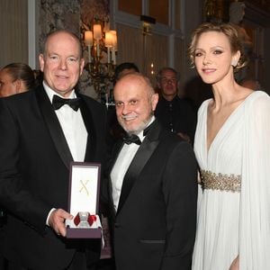Le prince Albert II de Monaco et la princesse Charlene avec l'un des partenaires de la soirée lors du Bal de Noël à la salle Empire de l'hôtel de Paris à Monaco, le 12 décembre 2025. © Bruno Bebert / Bestimage