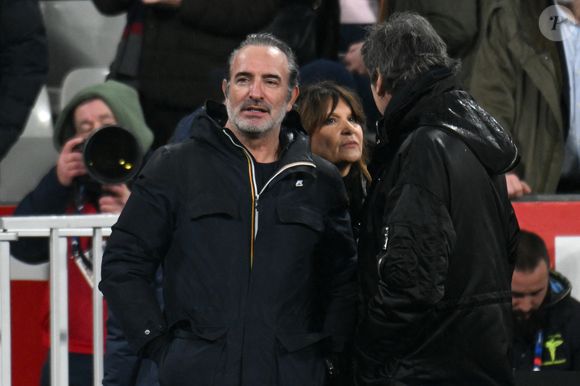 Jean Dujardin, JJean-Luc Reichmann et sa femme Nathalie Lecoultre - Célébrités dans les tribunes du match d'ouverture du Tournoi des six nations : France-Irlande (36-14) au Stade de France à Saint-Denis le 5 février 2026. © Lionel Urman/Bestimage
