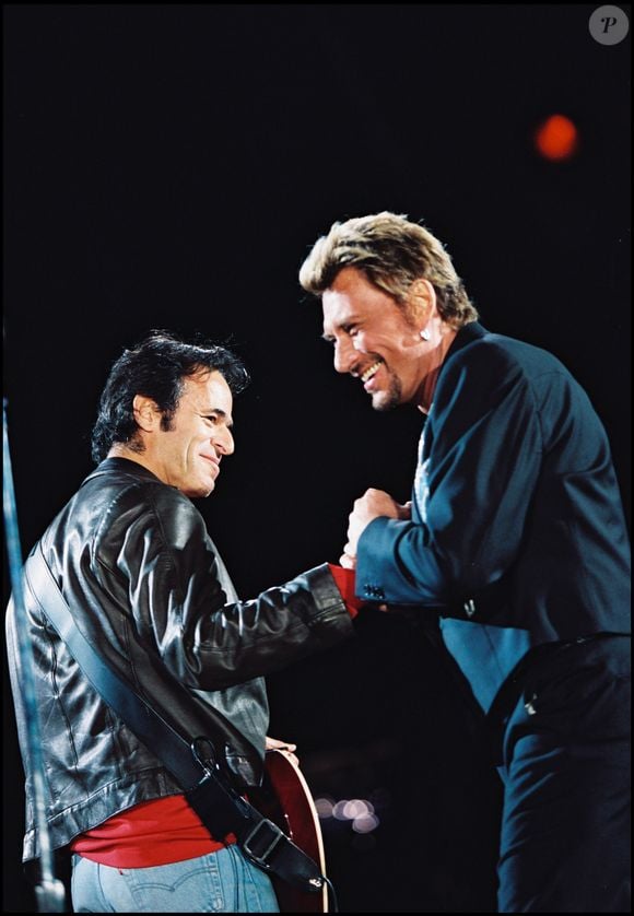 ARCHIVES - JEAN JACQUES GOLDMAN ET JOHNNY HALLYDAY SUR SCENE LORS D' UN CONCERT AU STADE DE FRANCE