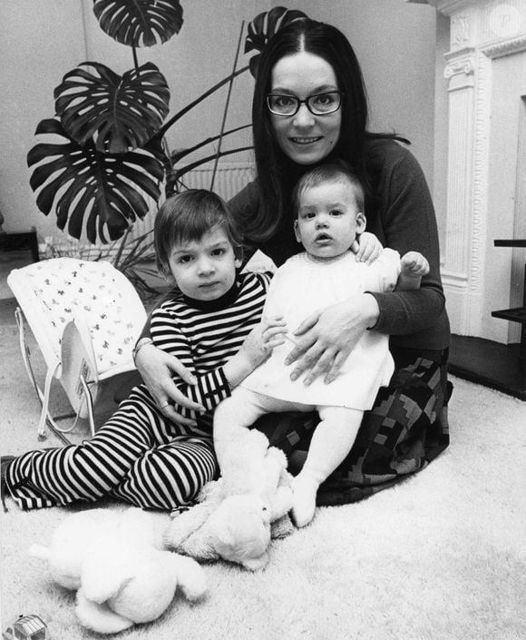 Passionnée par sa carrière et occupée à traverser le monde où elle était très demandée, Nana Mouskouri n'a pas pu voir ses enfants grandir. Elle les a confiés à une nounou.

La chanteuse Nana Mouskouri pose avec ses deux enfants dans son appartement de Londres. Photo par Keystone Press Agency/ZUMA Press Wire