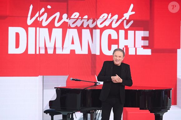 Au fil des décennies, il a marqué l'histoire de la télévision en présentant des programmes devenus cultes, à l'image du mythique Champs-Élysées dans les années 80, de l'impertinent Studio Gabriel ou encore de l'indéboulonnable Vivement dimanche, dont il tient toujours fermement les rênes chaque week-end. 

Exclusif - Michel Drucker - Enregistrement de l'émission Vivement dimanche au studio Rive Gauche , présentée par Michel Drucker . Diffusion sur France 3 le 29/03/2026. Photos prises le 18 mars 2026.
© Guillaume Gaffiot / Bestimage