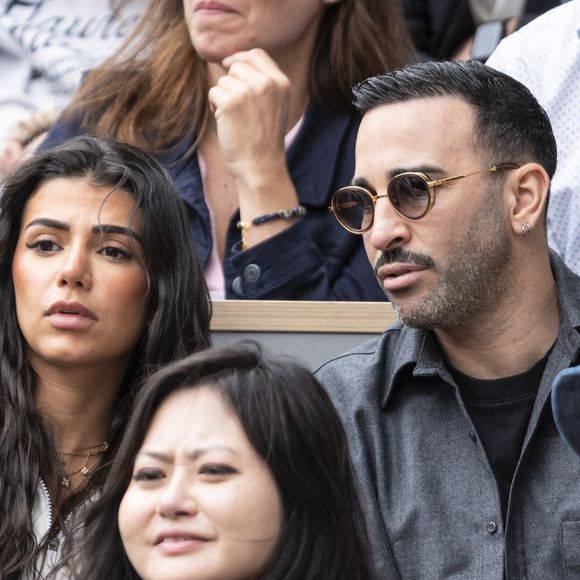 Adil Rami et sa compagne en tribunes lors des Internationaux de France de Tennis de Roland Garros 2025, à Paris, France, le 7 juin 2025. © Cyril Moreau/Bestimage