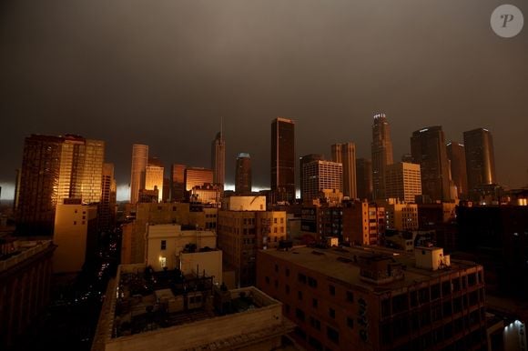 Los Angeles, CA - Le ciel est rempli de fumée alors que le soleil se lève sur le centre-ville de Los Angeles, le matin après les incendies qui ont ravagé la ville.