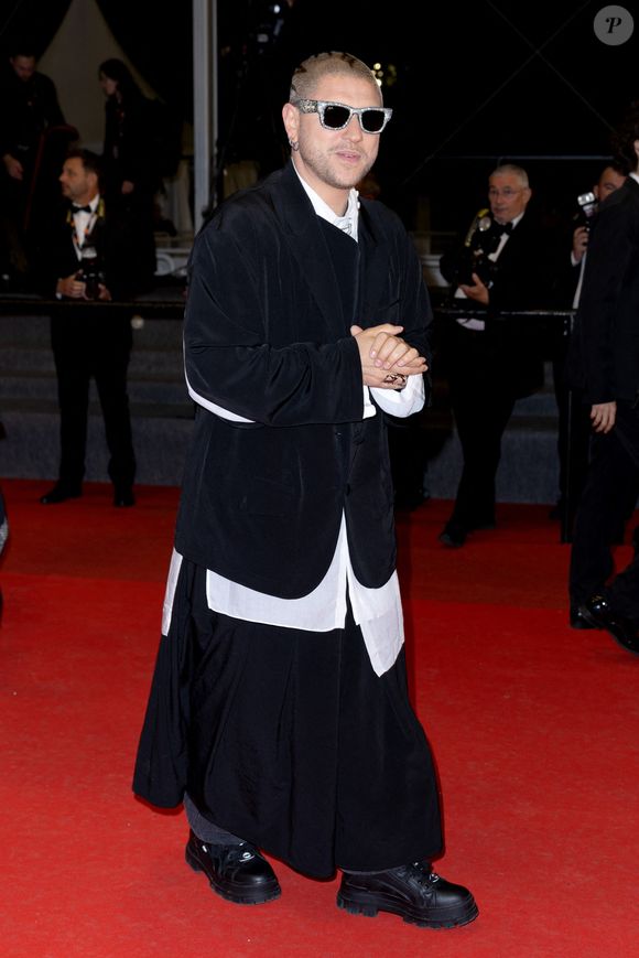 Pour Sanguine, il optait pour un ensemble noir structuré façon kimono ; pour Karma, il misait sur un costume blanc oversize très architectural.


Mosimann - Montée des marches du film " Sanguine " lors du 79ème Festival International du Film de Cannes, le 14 mai 2026. © Olivier Borde / Bestimage