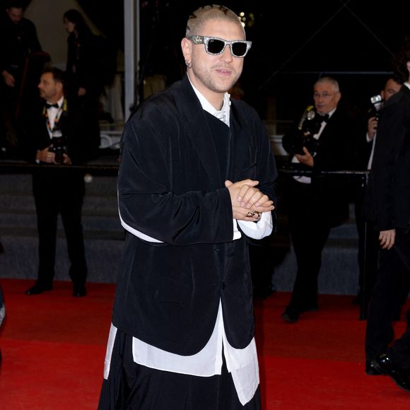 Pour Sanguine, il optait pour un ensemble noir structuré façon kimono ; pour Karma, il misait sur un costume blanc oversize très architectural.


Mosimann - Montée des marches du film " Sanguine " lors du 79ème Festival International du Film de Cannes, le 14 mai 2026. © Olivier Borde / Bestimage