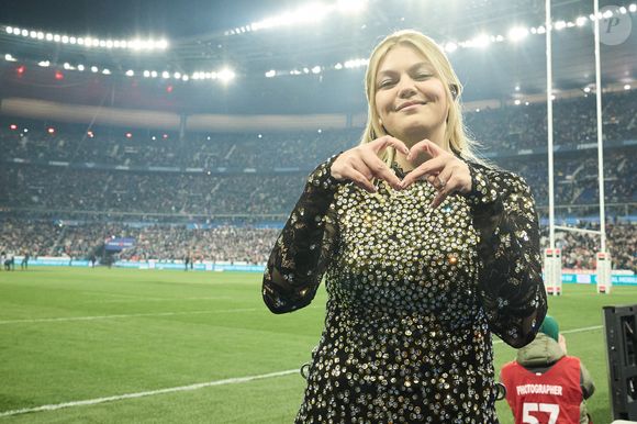 La chanteuse Louane (Louane Emera), représentante de la France au concours de l'Eurovision, interprète pour la première fois son titre Maman, en hommage à sa mère décédée lorsqu'elle avait 17 ans, devant les 80 000 spectateurs, suspendue sur une plateforme, plusieurs mètres au-dessus de la pelouse et des musiciens, du Stade de France à la mi-temps du match du Tournoi des Six Nations opposant la France à l'Écosse, à Saint-Denis, Seine Saint-Denis, France, le 15 mars 2025. © Cyril Moreau/Bestimage