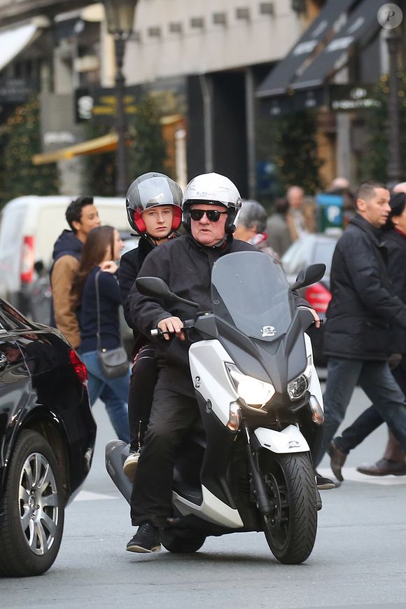 Gérard Depardieu et sa petite-fille Louise, la fille de Guillaume Depardieu, se promènent dans les rues de Paris en scooter. Le 19 décembre 2015. Crédit Bestimage