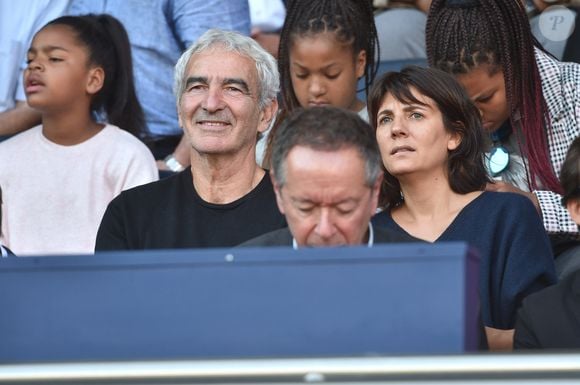 Raymond Domenech et sa femme Estelle Denis dans les tribunes lors du match de championnat de Ligue 1 Conforama opposant le Paris Saint-Germain au Racing Club de Strasbourg Alsace au Parc des princes à Paris, France, le 14 septembre 2019. Le PSG a gagné 1-0. © Giancarlo Gorassini/Bestimage