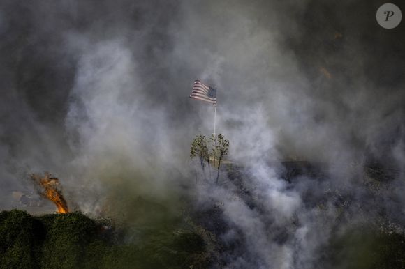 11 janvier 2025, Los Angeles, Californie, USA : 11 janvier 2024 : Un drapeau américain flotte au-dessus d'une section de Mandeville Canyon détruite par l'incendie de Palisades. (Crédit photo : © Mark Edward Harris/ZUMA Press Wire)