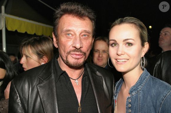 Le chanteur français Johnny Hallyday et son épouse Laeticia lors d'une soirée organisée à L'Etoile à Paris, France, le 15 mars 2005, pour présenter les voitures de l'équipe 'Paul Belmondo Racing' qui participera cette année à la course de voitures de sport des 24 heures du Mans. Photo par Benoit Pinguet/ABACA.