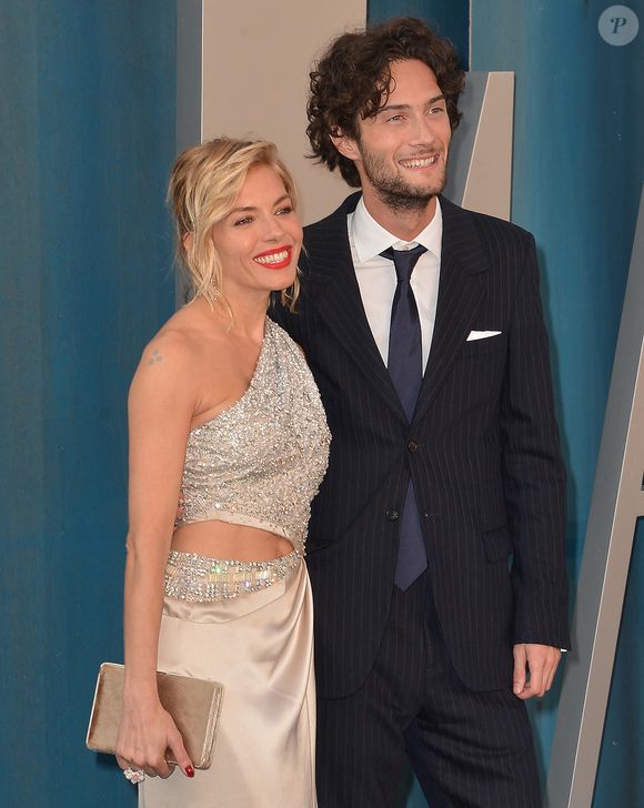 Sienna Miller officialise son couple avec son compagnon Oli Green, mannequin Burberry au photocall de la soirée "Vanity Fair" lors de la 94ème édition de la cérémonie des Oscars au Wallis Annenberg Center for the Performing Arts dans le quartier de Beverly Hills, à Los Angeles, Californie, Etats-Unis, le 27 mars 2022.