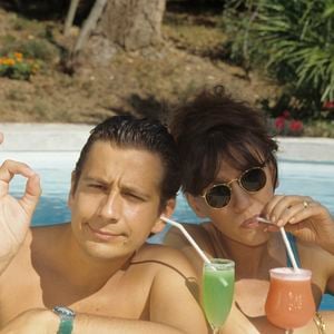 Archives - En France, à Saint-Tropez, Laurent Gerra et Virginie Lemoine en vacances au Mas de Chastelas, dans la piscine le 10 août 1995.