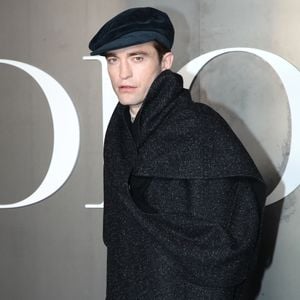 Près d'elle, Robert Pattinson (ambassadeur Dior depuis 2013) portait un châle gris avec un béret.

Robert Pattinson  au photocall du défilé Dior Homme à l'École-Militaire lors de la semaine de la mode masculine automne/hiver 2025-2026 à Paris, France, le 24 janvier 2025. © Bertrand Rindoff/Bestimage