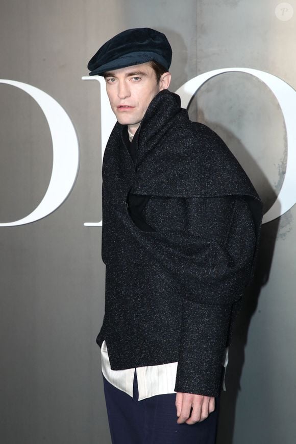 Près d'elle, Robert Pattinson (ambassadeur Dior depuis 2013) portait un châle gris avec un béret.

Robert Pattinson  au photocall du défilé Dior Homme à l'École-Militaire lors de la semaine de la mode masculine automne/hiver 2025-2026 à Paris, France, le 24 janvier 2025. © Bertrand Rindoff/Bestimage