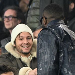 Vianney et Gims dans les tribunes du match de Ligue 1 McDonald's opposant le Paris Saint-Germain (PSG) à Lyon (3-1) au Parc des Princes à Paris le 15 décembre 2024.