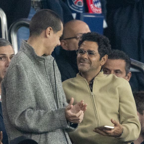 Jamel Debbouze et son fils Léon, Cindy Bruna et son futur mari Serge Ibaka - Célébrités dans les tribunes du match de Ligue des Champions entre le PSG contre le Bayern de Munich (1-2) au Parc des Princes à Paris le 4 novembre 2025. © Cyril Moreau/Bestimage