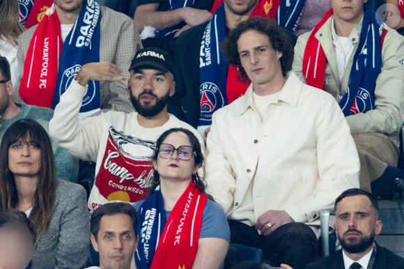 Caroline de Maigret, Oli et Paul de Saint Sernin, Grand Corps Malade avec son fils dans les tribunes du match de quart de finale aller de Ligue Des Champion au Parc des Princes à Paris, le 8 avril 2026. 

Photo : Cyril Moreau / Bestimage