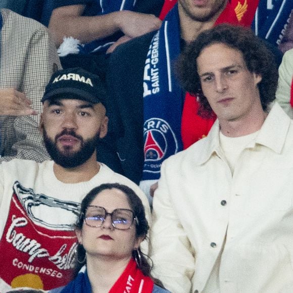 Caroline de Maigret, Oli et Paul de Saint Sernin, Grand Corps Malade avec son fils dans les tribunes du match de quart de finale aller de Ligue Des Champion au Parc des Princes à Paris, le 8 avril 2026. 

Photo : Cyril Moreau / Bestimage