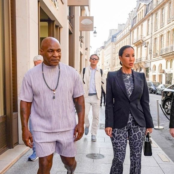 Exclusif - La légende de la boxe devenue podcasteur, Mike Tyson, et son épouse Lakiha Spicer ont été aperçus sortant de leur hôtel pour se rendre à l'aéroport de Paris, en France. Mike portait un ensemble court assorti, des mocassins et un chapelet autour du cou.