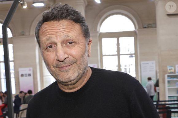 Il explique être accompagné de gardes du corps jour et nuit.

Arthur (Jacques Essebag) è Lors du bicentenaire de Hachette livre au Palais Brongniart " Les grandes rencontres Hachette " le 14 mars 2026. © Cédric Perrin/Bestimage