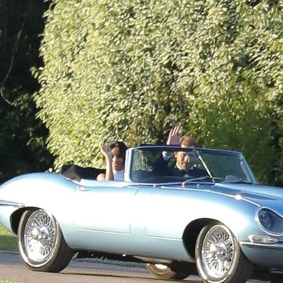 Le prince Harry, duc de Sussex, et Meghan Markle, duchesse de Sussex quittent le château de Windsor à bord d'une Jaguar Type E cabriolet en tenue de soirée  après leur cérémonie de mariage, pour se rendre à la réception à "Frogmore House" à Windsor le 19 mai 2018. (Agence / Bestimage).
