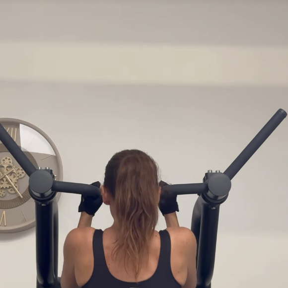 Son premier secret ? Les tractions assistées à la machine, un exercice incontournable pour renforcer le dos et les bras tout en gagnant en force.
