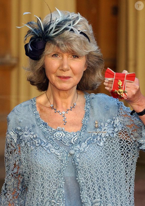 Jilly Cooper tenant son OBE, après qu'il lui ait été remis par le Prince de Galles de l'époque, au Palais de Buckingham. Photo by  John Stillwell/PA Wire