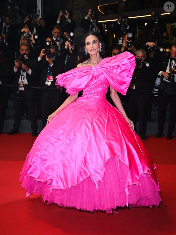 Lors de la projection de "Paper Tiger", elle est arrivée dans une spectaculaire robe rose bonbon de la marque avant-gardiste Matières Fécales, caractérisée par un immense nœud et un effet déstructuré. 

Demi Moore assiste au tapis rouge de ''Paper Tiger'' lors du 79ème Festival de Cannes, le 16 mai 2026, à Cannes, France. © Manuele Mangiarotti/IPA via ZUMA Press Wire/Bestimage