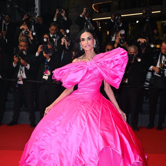 Lors de la projection de "Paper Tiger", elle est arrivée dans une spectaculaire robe rose bonbon de la marque avant-gardiste Matières Fécales, caractérisée par un immense nœud et un effet déstructuré. 

Demi Moore assiste au tapis rouge de ''Paper Tiger'' lors du 79ème Festival de Cannes, le 16 mai 2026, à Cannes, France. © Manuele Mangiarotti/IPA via ZUMA Press Wire/Bestimage