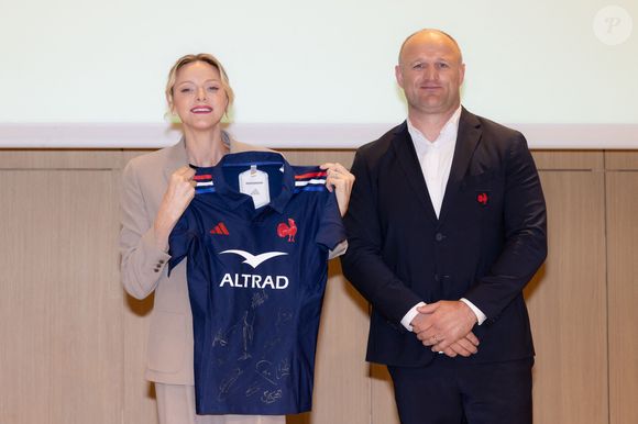 La princesse Charlène de Monaco se voit offrir un maillot dédicacé par les joueurs du XV de France de rugby, vainqueurs du tournoi des 6 nations 2025, des mains de William Servat, l'entraîneur du XV de France - La princesse C.de Monaco, en compagnie de son frère G.Wittstock, participe à la remise des prix de la "Journée du respect" au collège Charles III à Monaco, le 29 avril 2025. © Olivier Huitel / Pool Monaco / Bestimage