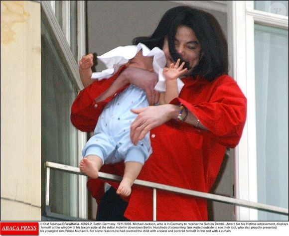 Le 19/11/2002. Michael Jackson, qui est en Allemagne pour recevoir le Bambi d'or, récompense pour l'ensemble de sa carrière, se montre à la fenêtre de sa luxueuse suite à l'hôtel Adlon de Berlin avec son plus jeune fils, le Prince Michael II, dit Blanket. © Olaf Selchow/DPA/ABACA.
