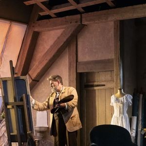 Dans un atelier réaliste avec vue sur la cathédrale, Monet retrouve l'inspiration grâce à Camille, une jeune modèle pleine de vie interprétée par Maud Baecker.
Clovis Cornillac dans "Dans les Yeux de Monet" au Théâtre de la Madeleine.