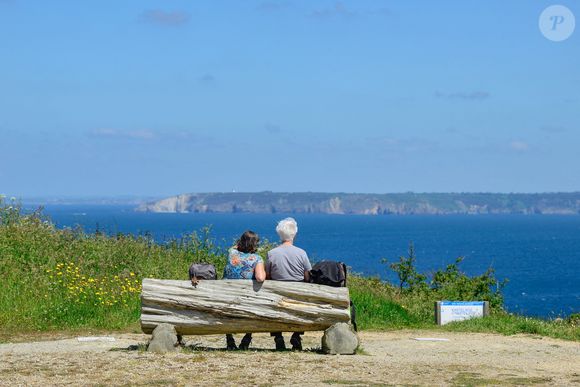 Beuzec-Cap-Sizun (29) : deux personnes assises sur un banc face à la mer sur le sentier cotier du GR34 au niveau de Castel Koz, vue sur le cap de la Chevre, presqu'ile de Crozon - Photo by Roignant JM/ANDBZ/ABACAPRESS.COM
