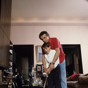 Archives - En France, à Paris, rendez-vous avec Michel Sardou chez lui dans le salon avec son fils Davy 9 ans, lui apprenant à jouer au golf. Novembre 1987
© Michel Marizy via Bestimage