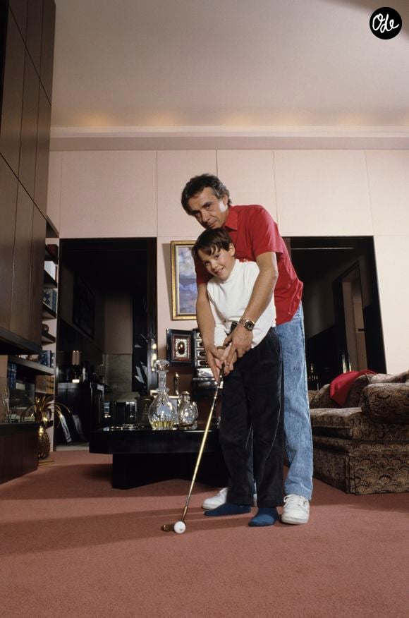Archives - En France, à Paris, rendez-vous avec Michel Sardou chez lui dans le salon avec son fils Davy 9 ans, lui apprenant à jouer au golf. Novembre 1987
© Michel Marizy via Bestimage