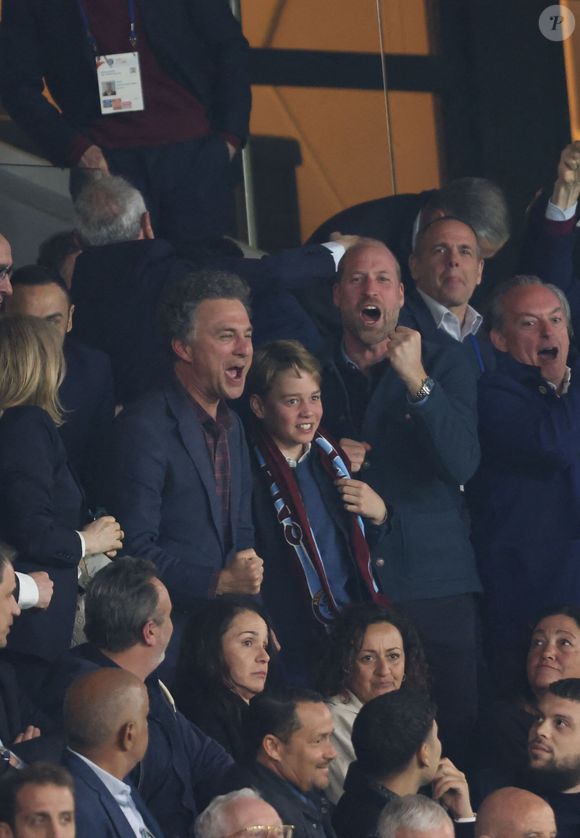 Poing levé et toutes les dents dehors.

Le prince William, prince de Galles, et son fils, le prince George de Galles, laissent éclater leur joie suite au but marqué par M.Rogers (Aston Villa) lors du match aller de la Ligue des Champions face au PSG au Parc des Princes, le 9 avril 2025.
© Cyril Moreau / Bestimage