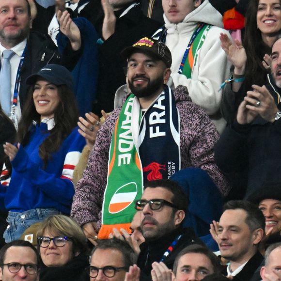 Iris Mittenaere, Jean Dujardin, Oli - Célébrités dans les tribunes du match d'ouverture du Tournoi des six nations : France-Irlande (36-14) au Stade de France à Saint-Denis le 5 février 2026. © Lionel Urman/Bestimage