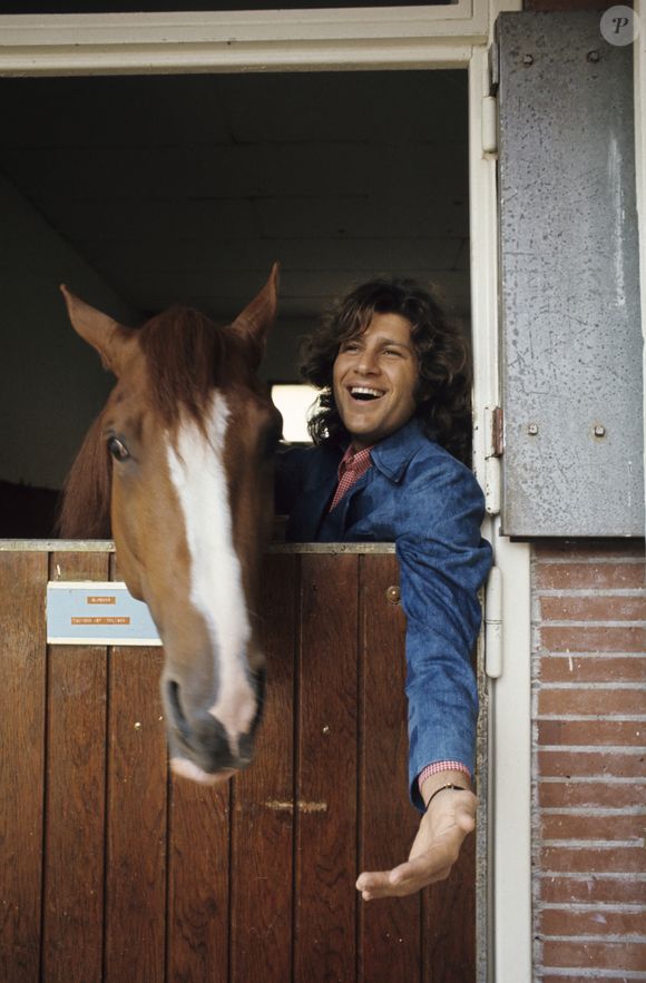 En France, Mike Brant, chanteur, avec son cheval Kullebert dans un haras en juin 1974. © Michel Ristroph via Bestimage