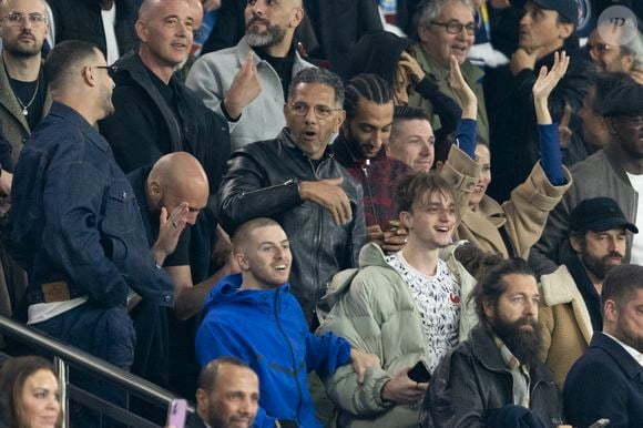 Roschdy Zem et son fils Chad Zem, Michou, , Adriana Lima et son compagnon Andre Lemmers, Benjamin Millepied - Célébrités des les tribunes lors du match aller du quart de finale de Ligue des champions entre le PSG et Aston Villa (3-1) au Parc des Princes à Paris le 9 avril 2025. © Cyril Moreau/Bestimage