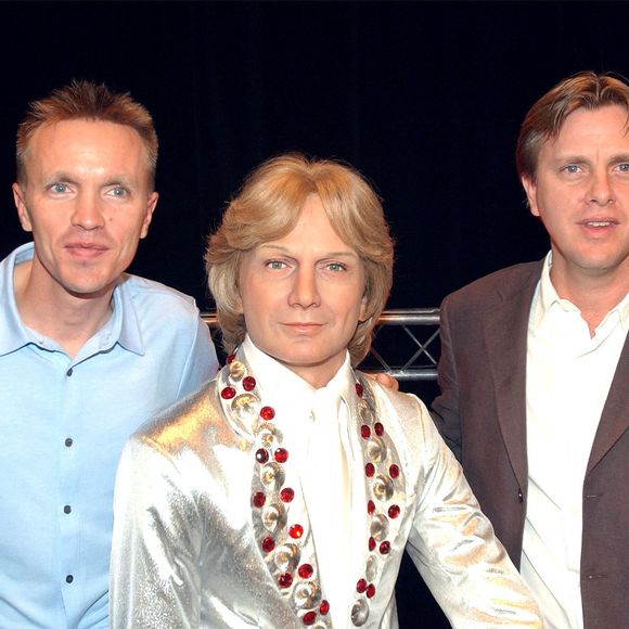 Claude François Jr et Marc François devant une statue de leur père au musée Grévin en 2004. Klein Bruno/ABACA