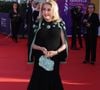 Invitée d’honneur, Catherine Deneuve s'est présentée sur le tapis rouge vêtue d’une tenue Chanel des plus chics. Elle portait alors une jupe évasée s’arrêtant à mi-mollet ainsi qu’un haut en maille composé de perles bleu ciel et dorées au col. Une veste assortie était délicatement posée sur ses épaules.

Catherine Deneuve - Arrivées à la cérémonie de clôture de la 52ème édition du Festival du Cinéma Américain de Deauville le 12 septembre 2026. © Denis Guignebourg / Bestimage