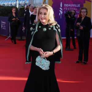 Invitée d’honneur, Catherine Deneuve s'est présentée sur le tapis rouge vêtue d’une tenue Chanel des plus chics. Elle portait alors une jupe évasée s’arrêtant à mi-mollet ainsi qu’un haut en maille composé de perles bleu ciel et dorées au col. Une veste assortie était délicatement posée sur ses épaules.

Catherine Deneuve - Arrivées à la cérémonie de clôture de la 52ème édition du Festival du Cinéma Américain de Deauville le 12 septembre 2026. © Denis Guignebourg / Bestimage
