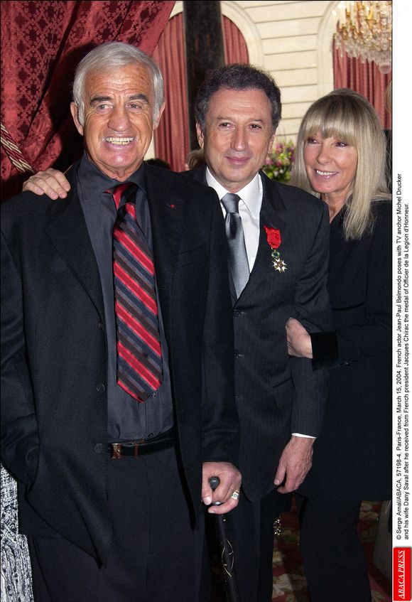 L'acteur français Jean-Paul Belmondo pose avec le présentateur de télévision Michel Drucker et son épouse Dany Saval après avoir reçu des mains du président français Jacques Chirac la médaille d'Officier de la Légion d'Honneur. © Serge Arnal/ABACA. 57198-4. Paris-France, 15 mars 2004.