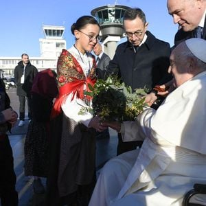 Le pape François est accueilli par le ministre français de l'Intérieur Bruno Retailleau (C) et des enfants après son atterrissage à l'aéroport international d'Ajaccio, sur l'île française de Corse, le 15 décembre 2024. Il s'agit du 45e voyage apostolique du pape à l'étranger. Photo : (EV) Vatican Media/ABACAPRESS.COM