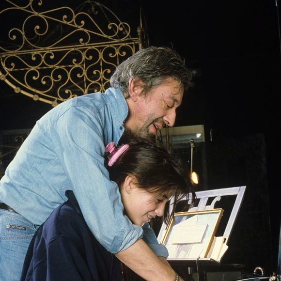 En France, à Paris, Serge Gainsbourg chez lui avec sa fille Charlotte dans son hôtel particulier de la rue de Verneuil, posant au milieu de son bric-à-brac où il entasse des objets hétéroclites en mai 1985.  © Michel Marizy via Bestimage