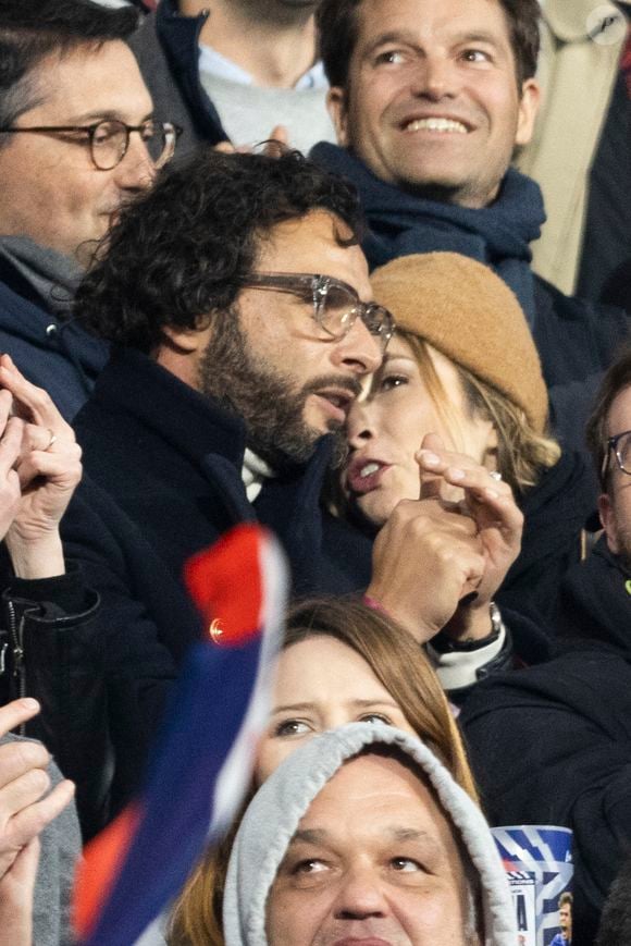 Maxim Nucci (Yodelice) et sa compagne Isabelle Ithurburu dans les tribunes lors du match de rugby du Tournoi des 6 Nations opposant la France à l'Angleterre au stade de France, à Saint-Denis, Seine Saint-Denis, France, le 19 mars 2022. © Cyril Moreau/Bestimage